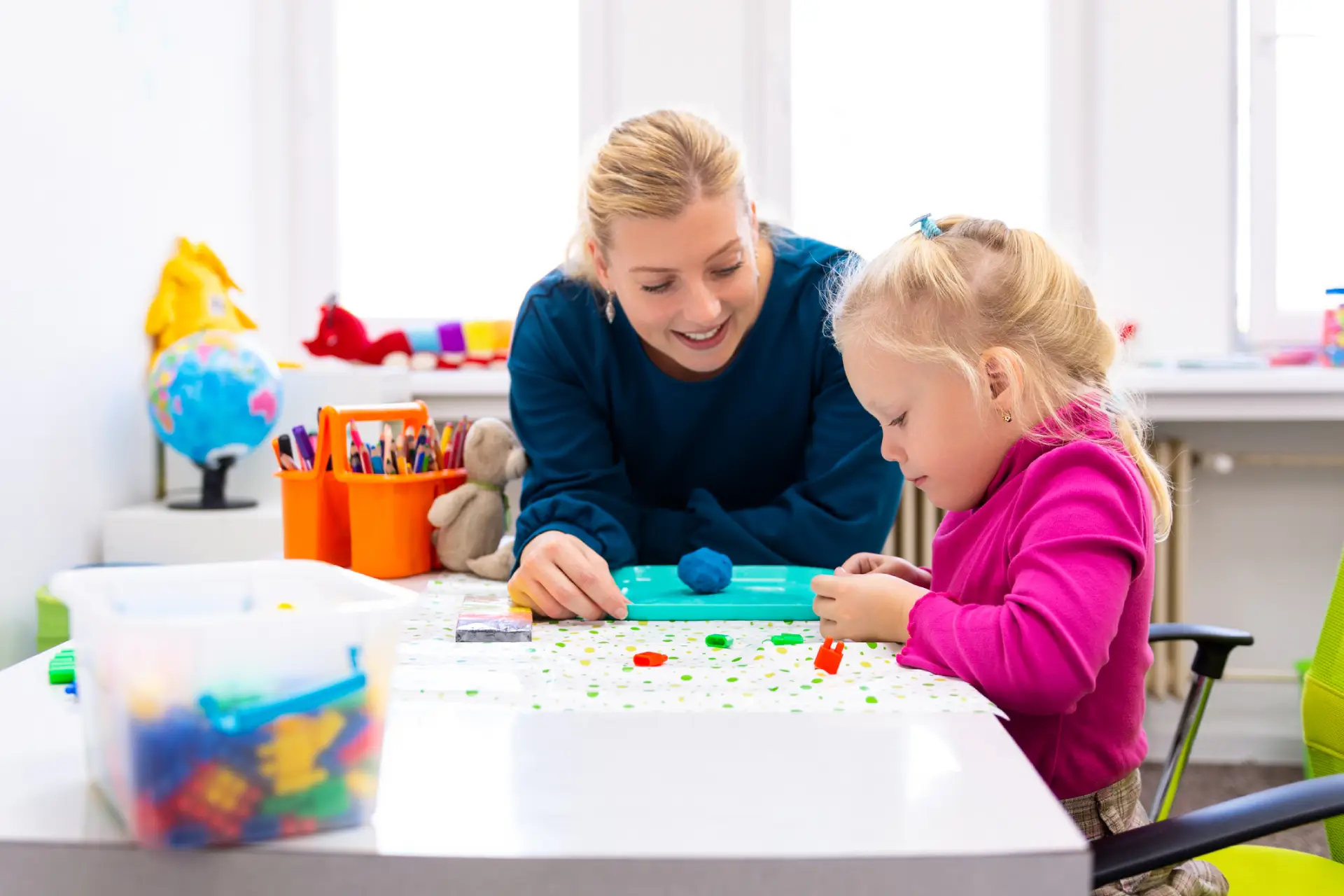 A toddler girl engages in sensory play exercises during a pediatric occupational therapy session at Tender Ones in Dacula, GA